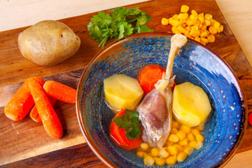 soup in a plate and ingredients included in it on a wooden board