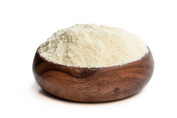 Full fat powdered milk in wooden bowl isolated on white