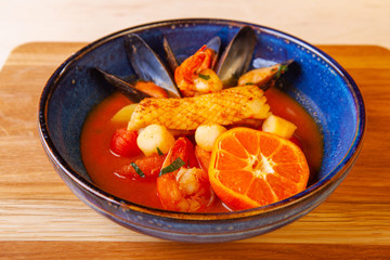 soup in a plate and ingredients included in it on a wooden board