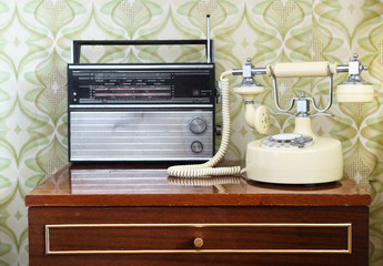 Retro radio on the table against the background of vintage wallpaper	