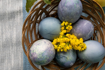 easter eggs and yellow flowers in the basket