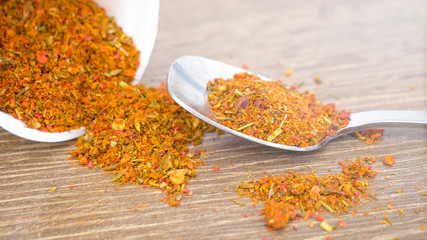 a mixture of spices, curry, paprika, hops suneli on a wooden table