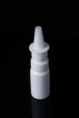 White plastic medical container on white, black background..nasal spray