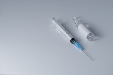 Medical vial for injection and a syringe,lays on the white table background