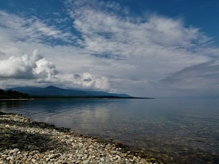 Beautiful stone shore of Lake Baikal against a cloudy sky before a thunderstorm.Russia.