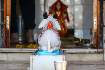 Nandi in front of a Shiv temple, from inside the temple,  selective focus,Indian goddess sculptures. Lord shiva linga (shiv ling) with lord nandiji outside the temple.