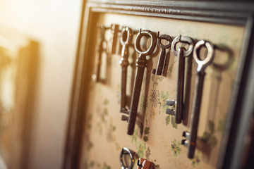Old worn out keys on the frame like hanger on the wall. Shallow DOF