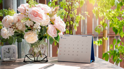 Calendar for Planner to plan daily timetable,appointment,organization and meeting agenda on desk,work from home.Desktop Calender 2020 glasses vase of rose and clock place on wooden table.