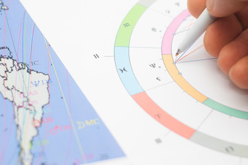 The workplace of a modern astrologer. Accessories of an astrologer. Printouts of computer astrological maps and tables. Astrological symbols and signs.