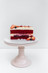 Delicious homemade red velvet cake with fresh berries on white background
