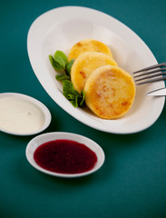 Round curd cheesecakes. Serving homemade food on a white plate. Cheesecake with mint for breakfast, a serving of three. High calcium appetizing healthy food.