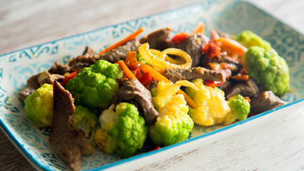 Beef with vegetables in a blue dish