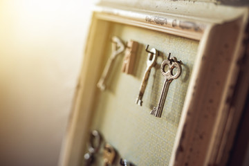 Old worn out keys on the frame like hanger on the wall. Shallow DOF