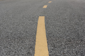 Obraz premium Yellow paint line on old asphalt bend