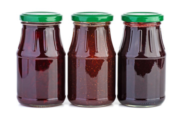Three glass jar with strawberry,cherry and black currants jam