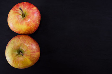 two apples on a black background. View from above. Copy space. Place for text.