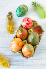 Obraz na płótnie Canvas Modern marble, brown and red easter eggs painted with organic onion on rustic table