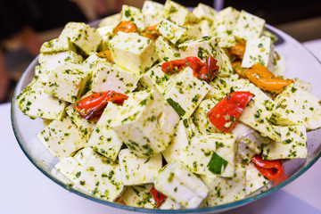 Cheese platter with organic cottage cheeses with vegetable toppings on glass plate wooden table.