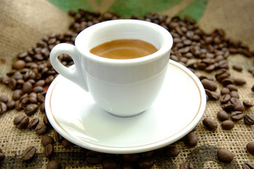 italian breakfast espresso cup on a jute canvas and with coffee beans