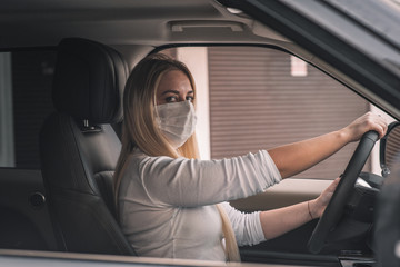 girl in a medical mask. beautiful blonde driving an expensive car. coronavirus, disease, infection, quarantine, medical mask, covid-19