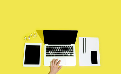 Fototapeta na wymiar Hand using gadgets, devices on top view, blank screen with copyspace, minimalistic style. Technologies, modern, marketing. Negative space for ad, flyer. Yellow color on background. Stylish, trendy.