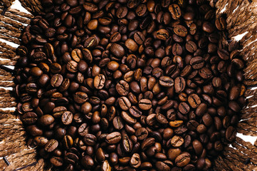 Coffee beans laid out on a white background with a basket