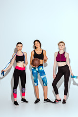 Fototapeta premium african american girl holding basketball and standing with attractive women on white