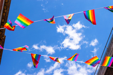 Pride flags against blue sky in Chinatown, London, UK
