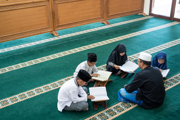 kid learning to read quran with muslim teacher or ustad