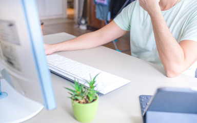 Fototapeta premium Man working at home on computer at the table