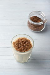 Simple healthy breakfast or snack. Natural yogurt with ground flax seeds in glasses on a light blue background