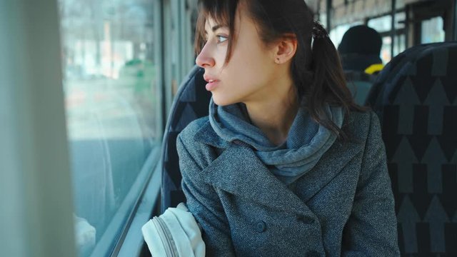 young woman sneezes in handkerchief in city bus. sick female in public transport without protective mask. spread of coronavirus and viral infection in public places.