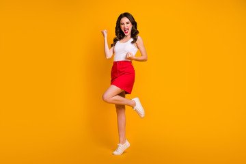 Fototapeta na wymiar Full size photo of funny lady open mouth raise fists crazy achievement screaming loud wear casual white tank-top red mini skirt shoes isolated yellow bright color background