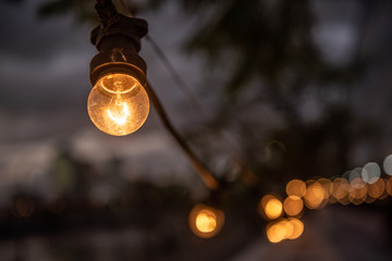 Warm light bulb. A line of  incandescent lamps in the street and bokeh.