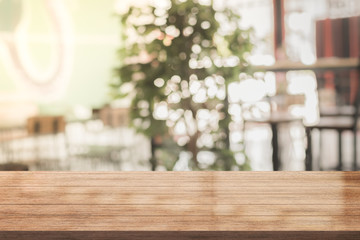 Empty of wood table top with blurred coffee shop on background