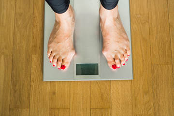 legs of an adult woman on electronic scales