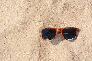 Fototapeta na wymiar Dark Brown Sunglasses on Beach Sand in Greece