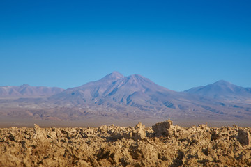 Fototapeta na wymiar Eroded soil and view of the landscape at Chaxa Lagoon & Flamingos National Reserve Conaf. an Pedro de Atacama, Antofagasta - Chile. Desert. Andes Range.