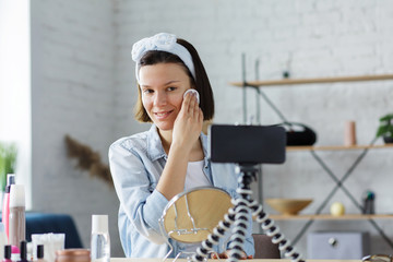 Young female blogger recording a tutorial video for her beauty blog about cosmetics.Vlogger testing...