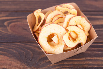 Dried dehydrated apple chips in craft bowl. Delicious organic eco-friendly snack for the whole family. Healthy eating concept.