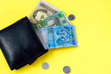 Ukrainian small money hryvnia and a penny in a leather black wallet.