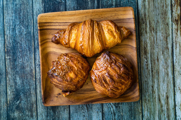 Assortment of Assorted Croissant Varieties om Wooden Plate / Variety of Bakery Pastries.