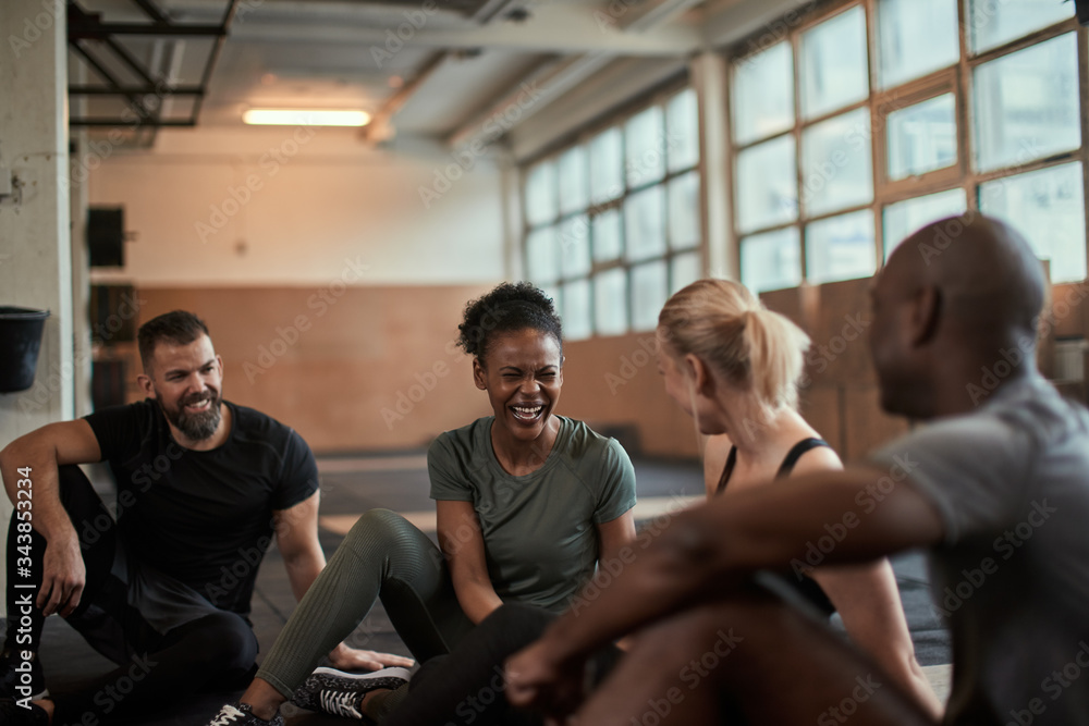 Wall mural Fit group of diverse friends laughing together at the gym