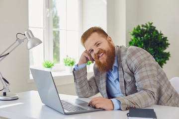 Work online at home office. Funny fat man works using a laptop in the apartment room.