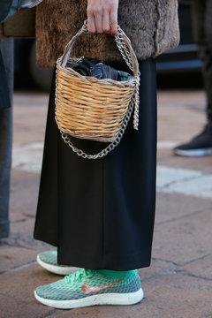 Woman with wicker basket bag and green Nike shoes on January 15, 2017 in Milan, Italy
