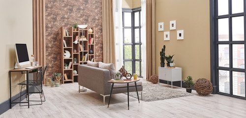 Brown living room interior decoration with wallpaper detail, grey sofa, wooden coffee table and working desk in the living room.