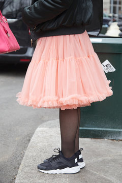 Woman with pink tulle skirt and black and white Nike sneakers shoes on January 15, 2018 in Milan, Italy