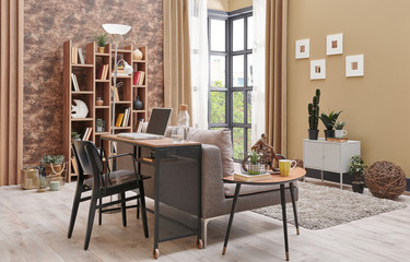 Brown living room interior decoration with wallpaper detail, grey sofa, wooden coffee table and working desk in the living room.