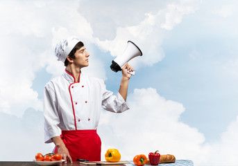 Young chef standing with megaphone in hand