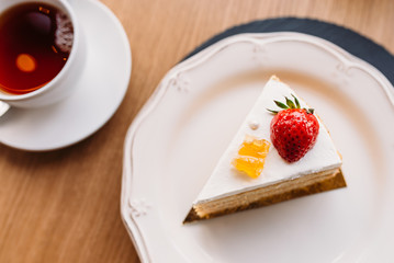 Piece of cake with a tea on the table.